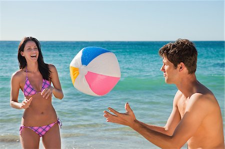 plástico - Couple having fun while playing beach ball game with the ocean in background Foto de stock - Sin royalties Premium, Código: 6109-06006188