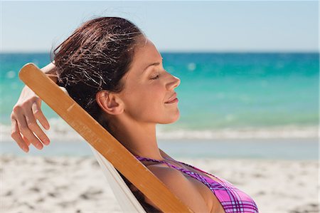 Woman in bikini taking a sunbath on the beach Stock Photo - Premium Royalty-Free, Code: 6109-06006135