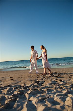 people walking on the beach sunset - Couple marchant sur la plage au moment du coucher du soleil, la mer en arrière-plan Photographie de stock - Premium Libres de Droits, Code: 6109-06006281