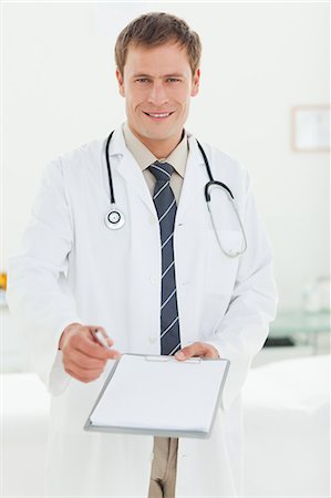 professional medical - Smiling young doctor asking for signature Stock Photo - Premium Royalty-Free, Code: 6109-06006347