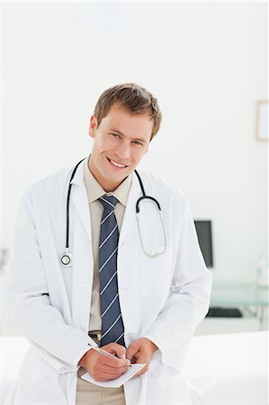 simsearch:6109-06005901,k - Smiling male doctor filling in prescription Fotografie stock - Premium Royalty-Free, Codice: 6109-06006364