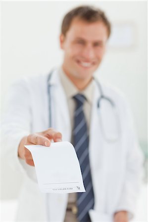 simsearch:6109-06006352,k - Smiling male doctor handing over prescription Foto de stock - Sin royalties Premium, Código: 6109-06006366