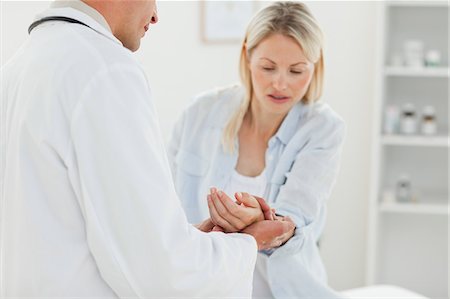 Male doctor checking his patients pulse Stock Photo - Premium Royalty-Free, Code: 6109-06006399