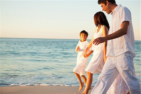 Family walking hand in hand at sunset time on the beach Stock Photo - Premium Royalty-Free, Code: 6109-06006303