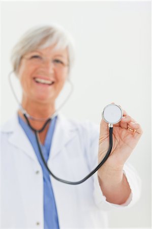 simsearch:6109-06006352,k - Stethoscope being used by smiling mature doctor Foto de stock - Sin royalties Premium, Código: 6109-06006331