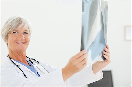 simsearch:6109-06006352,k - Side view of smiling mature doctor with an x-ray Foto de stock - Sin royalties Premium, Código: 6109-06006336