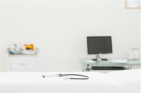 examen médical - Stethoscope lying on a mattress in an examination room Foto de stock - Sin royalties Premium, Código: 6109-06006338