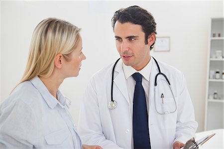 simsearch:6109-06006352,k - Doctor talking with his female patient in his examination room Foto de stock - Sin royalties Premium, Código: 6109-06006443