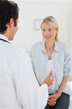 examination room - Back view of patient listening to her male doctor Stock Photo - Premium Royalty-Free, Code: 6109-06006447