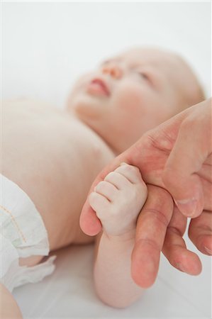 Close up of little baby holding adults finger Stock Photo - Premium Royalty-Free, Code: 6109-06006469
