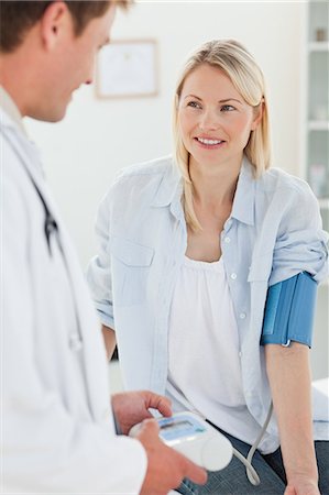 Smiling young woman getting her blood pressure measured Foto de stock - Sin royalties Premium, Código: 6109-06006409