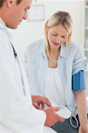 Young woman getting her blood pressure measuring results explained by her doctor Foto de stock - Sin royalties Premium, Código: 6109-06006410
