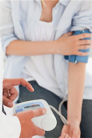 Male doctor measuring the blood pressure of his patient Stock Photo - Premium Royalty-Free, Code: 6109-06006412