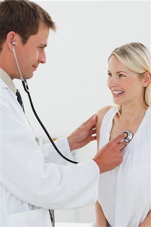 Smiling male doctor checking his patients heart beat Foto de stock - Sin royalties Premium, Código: 6109-06006427