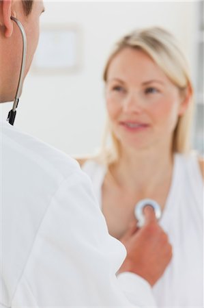 doctor with heart patient - Rear view of doctor taking his female patients heart beat Stock Photo - Premium Royalty-Free, Code: 6109-06006433
