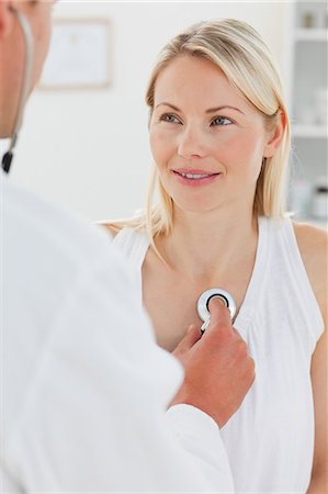 Woman getting her heart beat checked by her male doctor Stock Photo - Premium Royalty-Free, Code: 6109-06006432