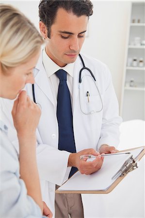 expert - Young doctor and his patient looking at clipboard together Stock Photo - Premium Royalty-Free, Code: 6109-06006439