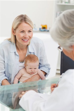 simsearch:6109-06006581,k - Mère souriante avec son petit bébé Voir le médecin Photographie de stock - Premium Libres de Droits, Code: 6109-06006562