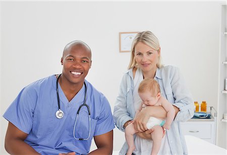 simsearch:6109-06006581,k - Docteur souriant assis à côté de la mère avec son petit bébé Photographie de stock - Premium Libres de Droits, Code: 6109-06006586