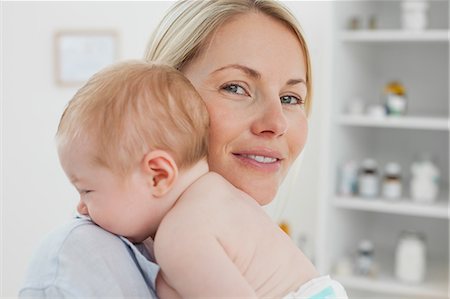 simsearch:6109-06006613,k - Side view of smiling mother holding her baby close Stock Photo - Premium Royalty-Free, Code: 6109-06006592