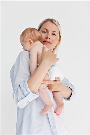 simsearch:6109-06006613,k - Woman holding her baby against a white background Stock Photo - Premium Royalty-Free, Code: 6109-06006596