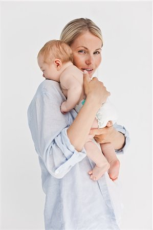 simsearch:6109-06006613,k - Mother hugging her baby against a white background Stock Photo - Premium Royalty-Free, Code: 6109-06006598
