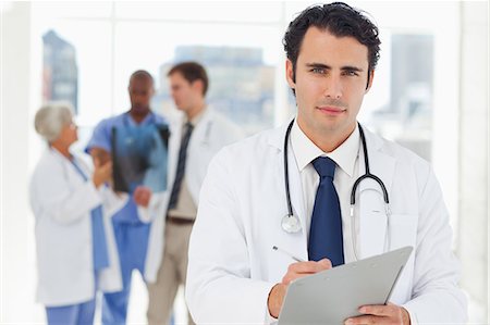 pic of medical staff - Young doctor with his clipboard and three colleagues behind him Stock Photo - Premium Royalty-Free, Code: 6109-06006525