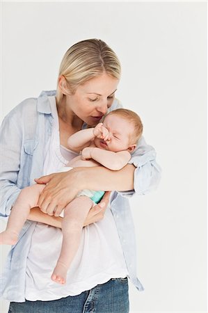 simsearch:6109-06006613,k - Woman holding her little baby against a white background Stock Photo - Premium Royalty-Free, Code: 6109-06006607