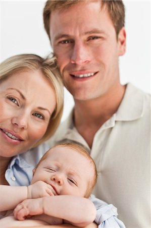 simsearch:6109-06006613,k - Close up of smiling mother and father with their little baby against a white background Stock Photo - Premium Royalty-Free, Code: 6109-06006616