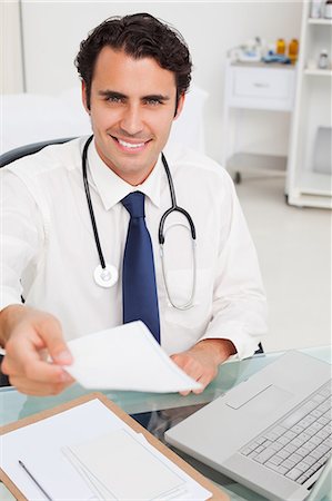 prescription doctor - Smiling young doctor handing over a prescription Stock Photo - Premium Royalty-Free, Code: 6109-06006749