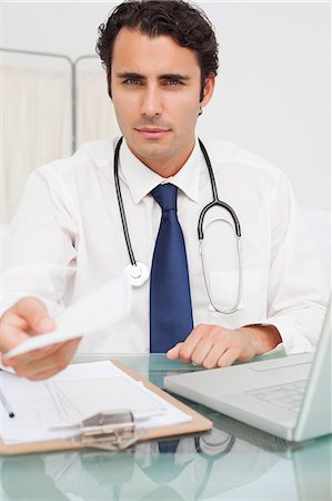 prescription doctor - Young doctor holding prescription in his hand Stock Photo - Premium Royalty-Free, Code: 6109-06006752