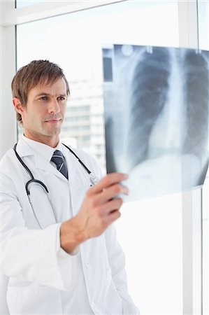 simsearch:6109-06006829,k - Serious surgeon holding a chest x-ray in front of a window Foto de stock - Sin royalties Premium, Código: 6109-06006793