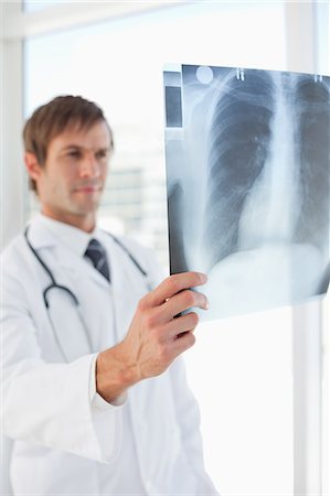 stethoskop - Radiographie pulmonaire qui s'est tenue par un chirurgien sérieux devant une fenêtre Photographie de stock - Premium Libres de Droits, Code: 6109-06006794