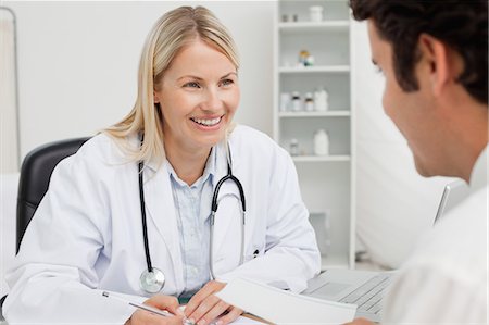 doctor advising patient in hospital - Smiling female doctor talking to her patient Stock Photo - Premium Royalty-Free, Code: 6109-06006716