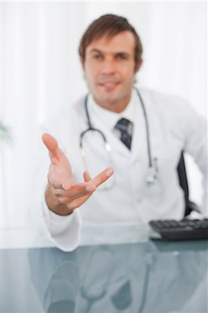 extend - Hand extended by a relaxed doctor sitting at the desk Stock Photo - Premium Royalty-Free, Code: 6109-06006849