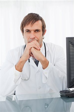 simsearch:6109-06006829,k - Thoughtful doctor placing his hands in front of his chin Foto de stock - Sin royalties Premium, Código: 6109-06006859