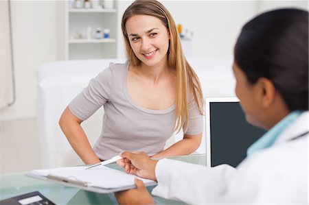 doctor at desk with patient - Relaxed patient looking at her doctor while smiling and listening to explanations Stock Photo - Premium Royalty-Free, Code: 6109-06006882