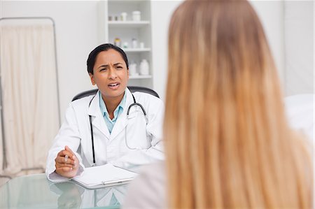 pflegekraft - Schwere Praktiker im Gespräch mit ihrer Patientin beim sitzen an ihrem Schreibtisch Stockbilder - Premium RF Lizenzfrei, Bildnummer: 6109-06006885