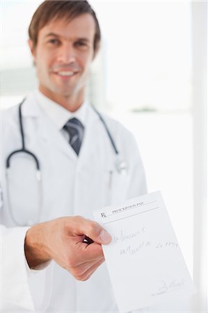 receta - A prescription held by a smiling surgeon in front of a window Foto de stock - Sin royalties Premium, Código: 6109-06006816