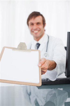 simsearch:6109-06006876,k - Zwischenablage lächelnd Chirurg sitzt an seinem Schreibtisch im Besitz Stockbilder - Premium RF Lizenzfrei, Bildnummer: 6109-06006836