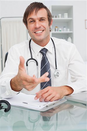 stethoscope - Smiling doctor giving explanations while looking at the camera Stock Photo - Premium Royalty-Free, Code: 6109-06006943