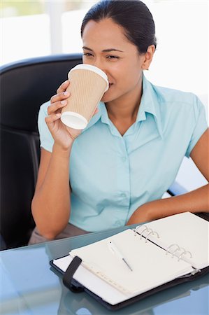 simsearch:6109-06006973,k - Secretary drinking coffee while sitting at a desk and looking towards the side Stock Photo - Premium Royalty-Free, Code: 6109-06006981