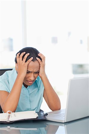 simsearch:6109-06006973,k - Upset secretary placing her hands on her head while sitting at a desk Stock Photo - Premium Royalty-Free, Code: 6109-06006990