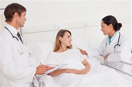 doctors room with patient image - Serious doctor talking to her patient while touching her shoulder Stock Photo - Premium Royalty-Free, Code: 6109-06007049