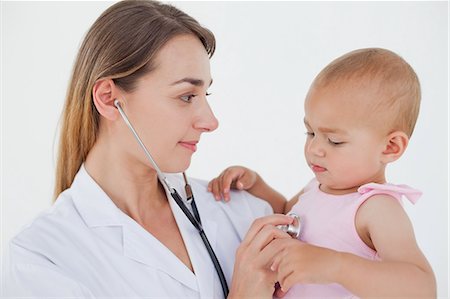 pédiatre - Docteur en regardant le beau bébé tout en maintenant et en lui auscultating Photographie de stock - Premium Libres de Droits, Code: 6109-06007095