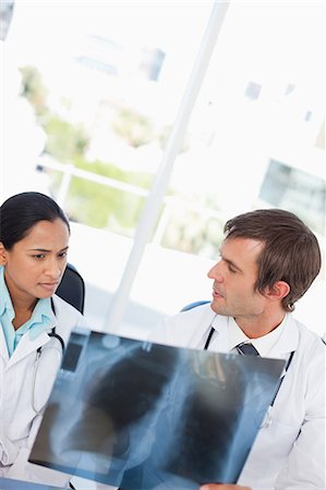 simsearch:6109-06006905,k - Serious doctor looking at a chest x-ray while her colleague is listening to her Stock Photo - Premium Royalty-Free, Code: 6109-06007009