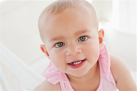 Adorable baby staring at the camera while opening her mouth Stock Photo - Premium Royalty-Free, Code: 6109-06007034