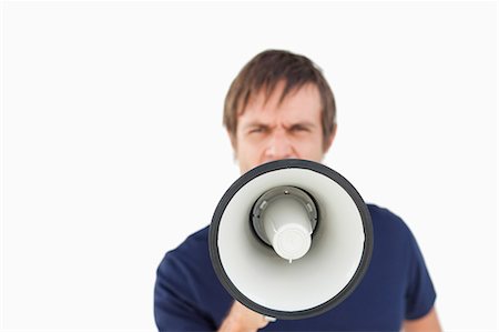 Furious man shouting while using a megaphone against a white background Stock Photo - Premium Royalty-Free, Code: 6109-06007144