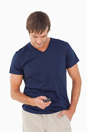 simsearch:6109-06007112,k - Relaxed man sending a text with his mobile phone against a white background Foto de stock - Sin royalties Premium, Código: 6109-06007122