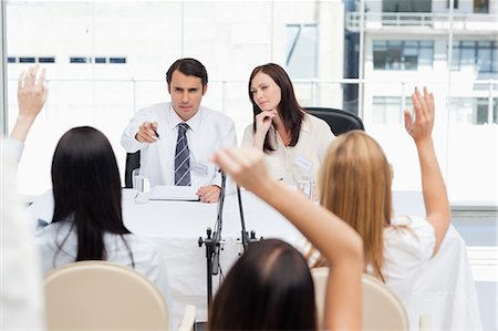 raised - Businessman pointing towards members of the audience who have their arms raised above their heads Stock Photo - Premium Royalty-Free, Code: 6109-06007289